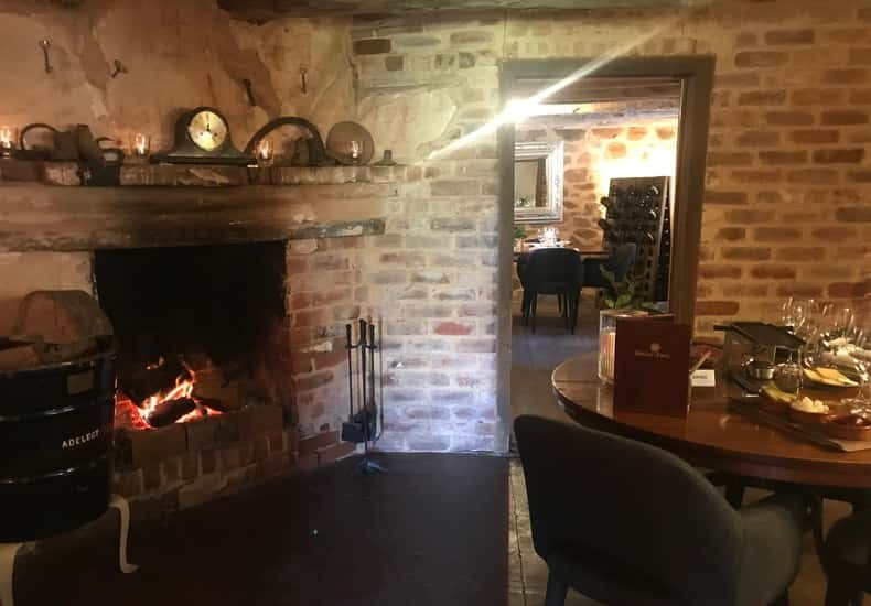 A fire burning in a brick hearth in a cellar-door tasting room